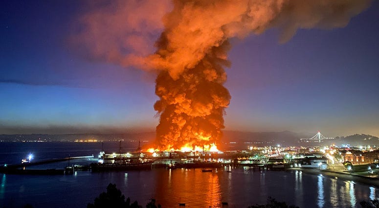 Roughly 100 firefighters are battling a four-alarm fire at a warehouse building at Fisherman's Wharf in San Francisco.