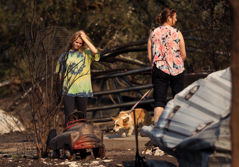 Ashley LaFranchi (L) and Stephanie LaFranchi (R) walk through a family home that was destroyed by the Kincade Fire on October 28, 2019 in Calistoga.