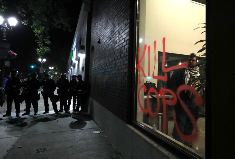 OAKLAND, CALIFORNIA - MAY 29: Police officers stand in line during a protest sparked by the death of George Floyd while in police custody on May 29, 2020 in Oakland, California.