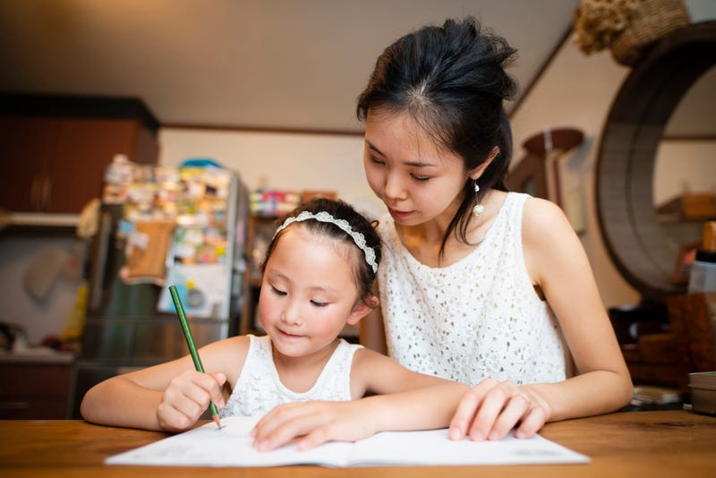 A mother helps her daughter with homework