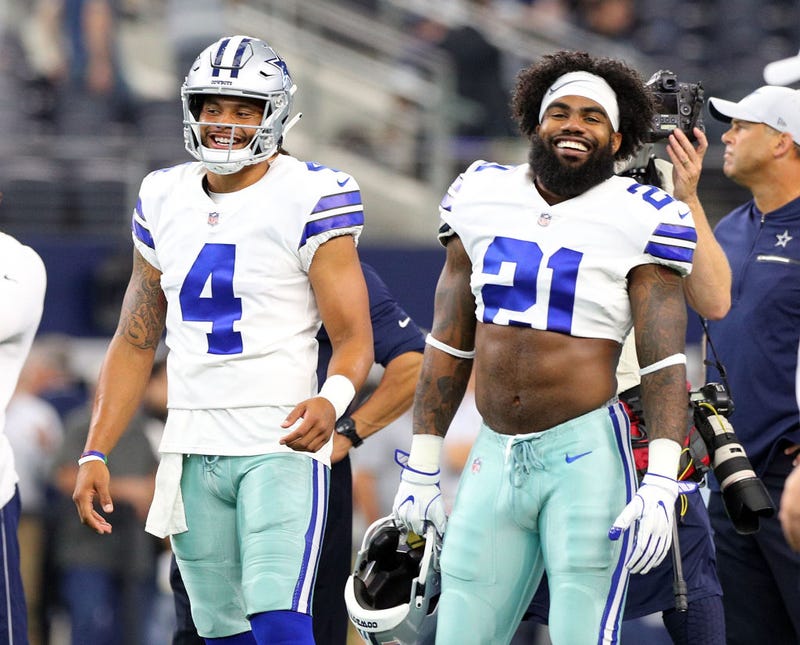 Dak Prescott #4 of the Dallas Cowboys and Ezekiel Elliott #21 of the Dallas Cowboys smile during warm ups before the preseason game against the Arizona Cardinals at AT&T Stadium on August 26, 2018 in Arlington, Texas.
