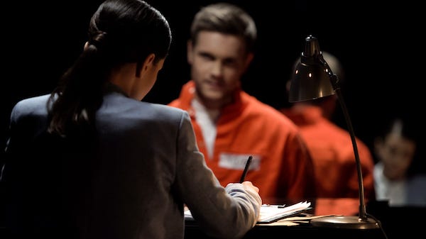 Female defense attorney writing accused prisoners statements for court