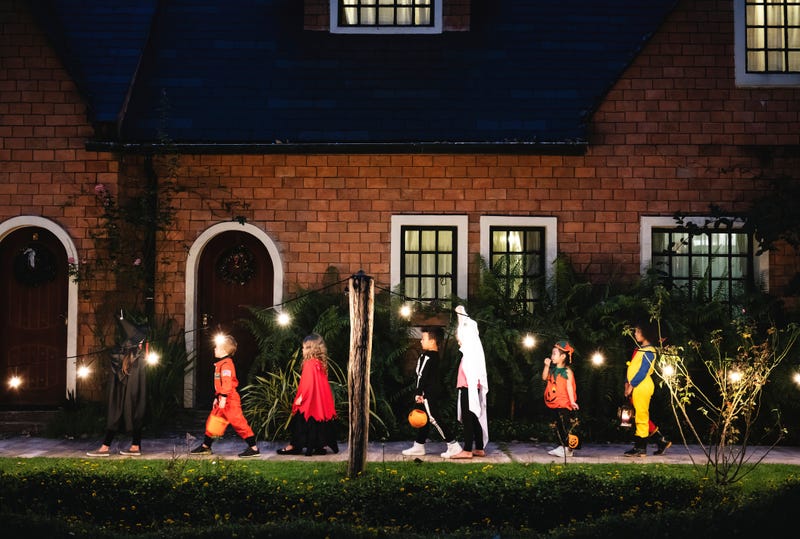 line of trick or treaters walking up to house