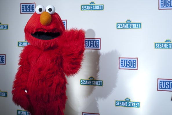 Elmo waves to the camera.