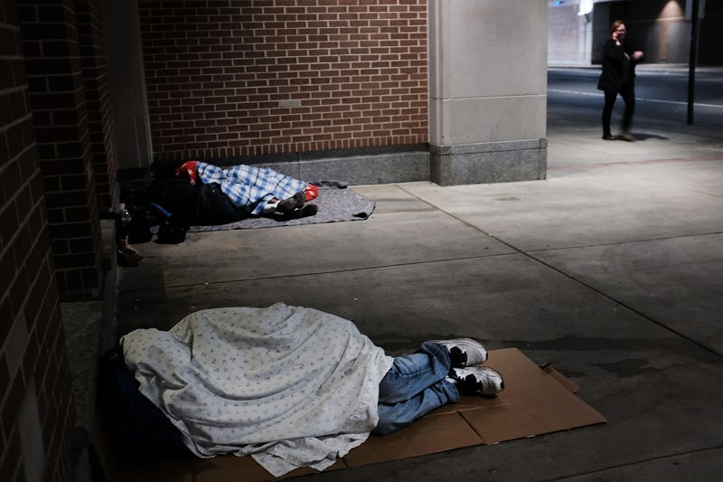 Homeless people sleep on a sidewalk in Philadelphia, Pennsylvania.