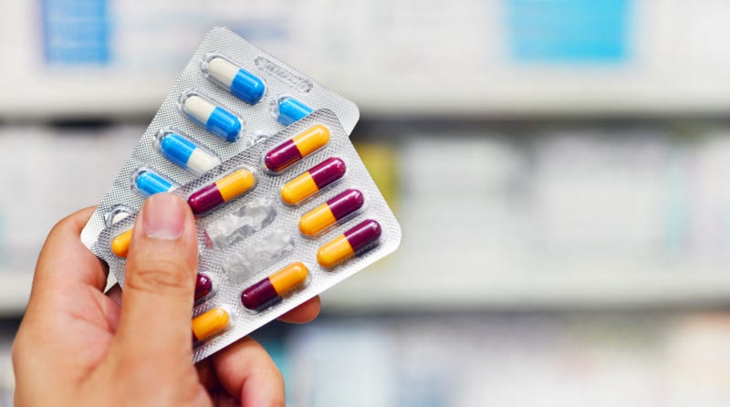 A hand holding medical tablets in wrappers