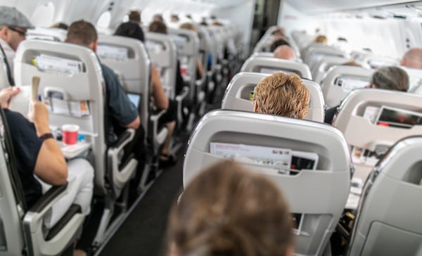 Airplane cabin with passengers in seats
