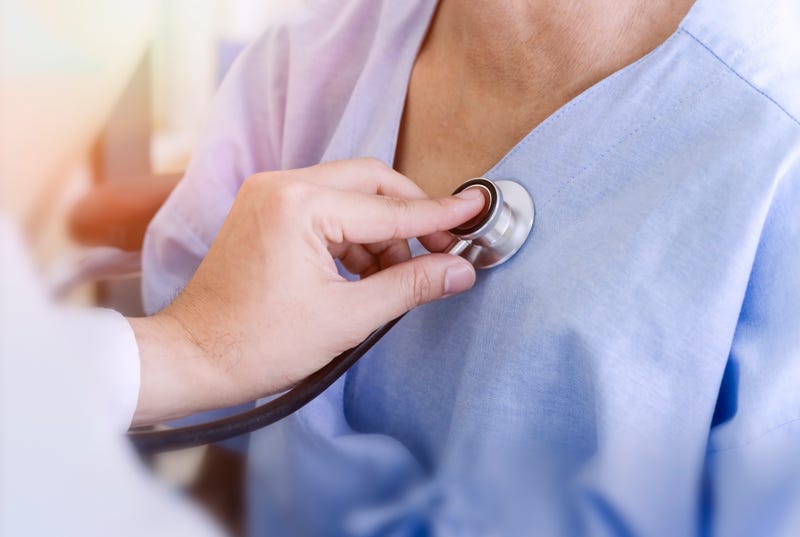 Doctor checking patient's heart