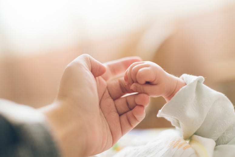 Newborn holding parent's hand