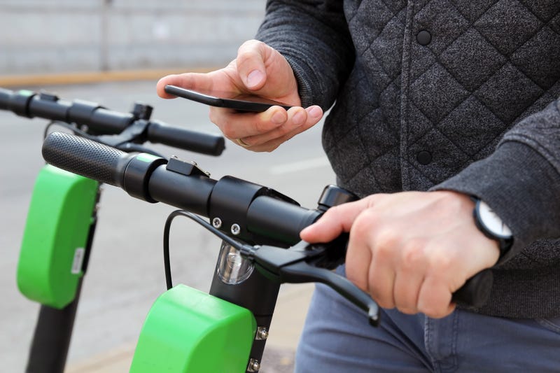 Close up image of a man on an electric scooter paying online