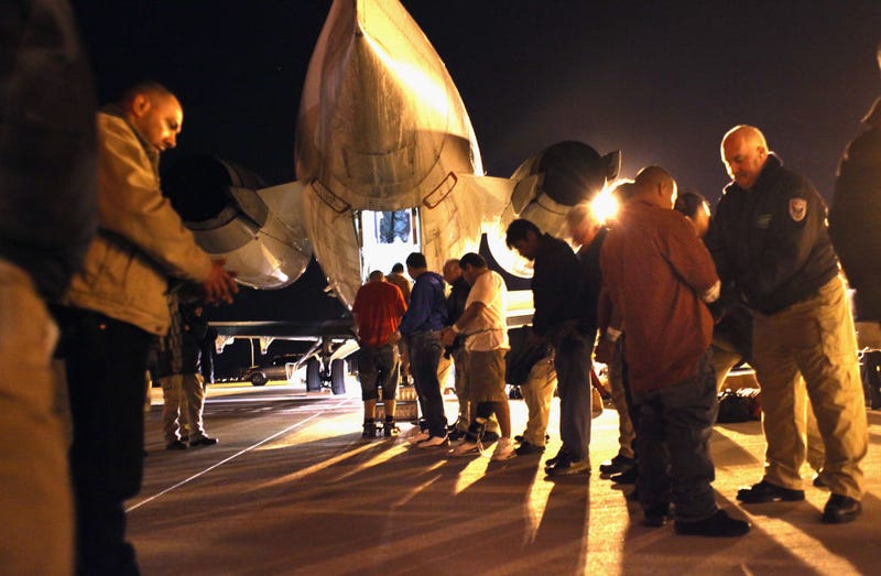Immigration and Customs Enforcement (ICE), officers pat down undocumented immigrants from El Salvador before boarding them onto a deportation flight