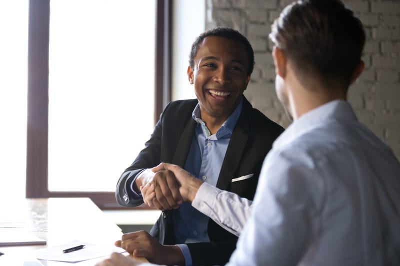 Two men in business attire shake hands