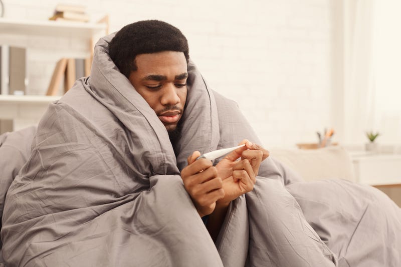 A sick man checks his temperature