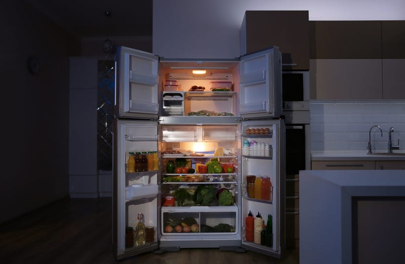 An open fridge at night with the light on