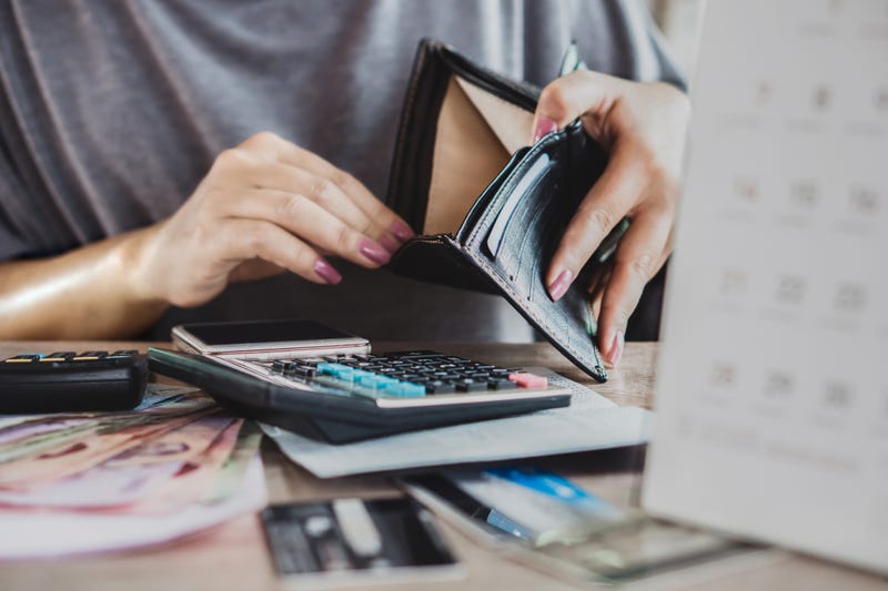 woman looks in empty wallet