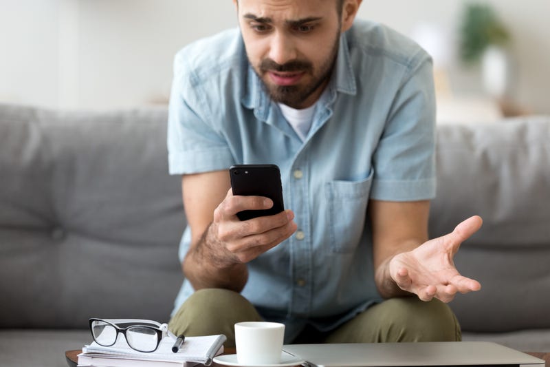A man looks confused at his phone