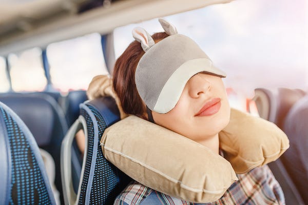Woman with sleeping mask sitting on bus