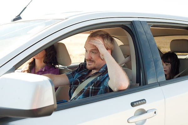 Frustrated dad driving with family