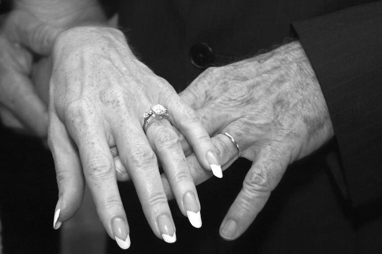 Elderly couple showing wedding rings