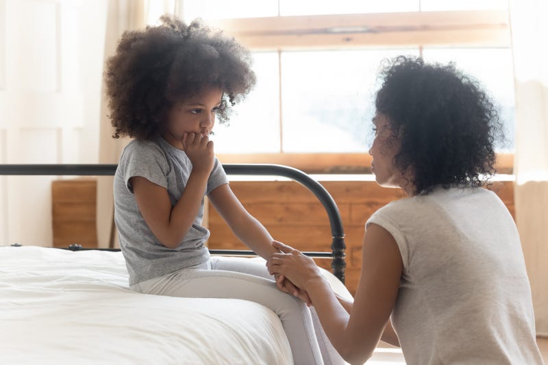 A mother holds her daughters hand as they talk