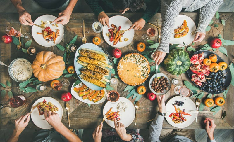 Friends eating at Thanksgiving Day table with vegetarian meals