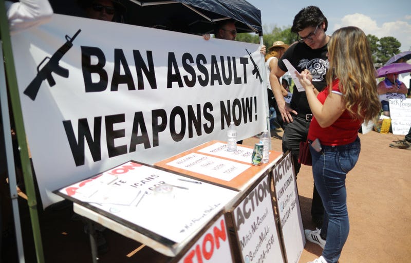 A 'Ban Assault Weapons Now' sign is displayed near a voter registration table on August 7, 2019 in El Paso, Texas.