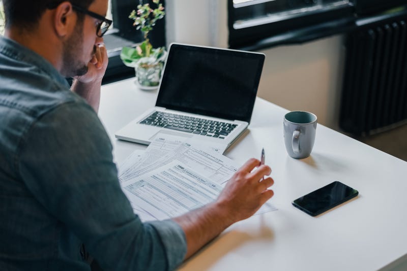 businessman or entrepreneur in office filing income tax return papers documents for IRS