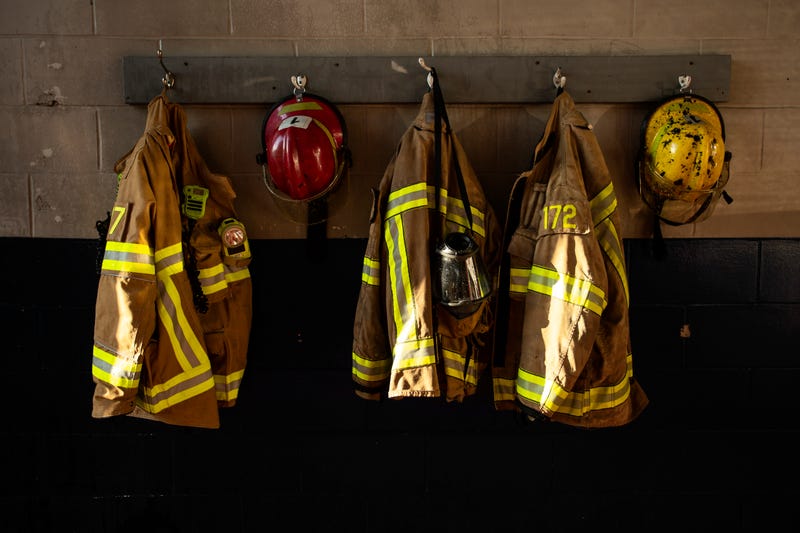 firefighter protection clothes and respiratory mask hanging on the fire station wall