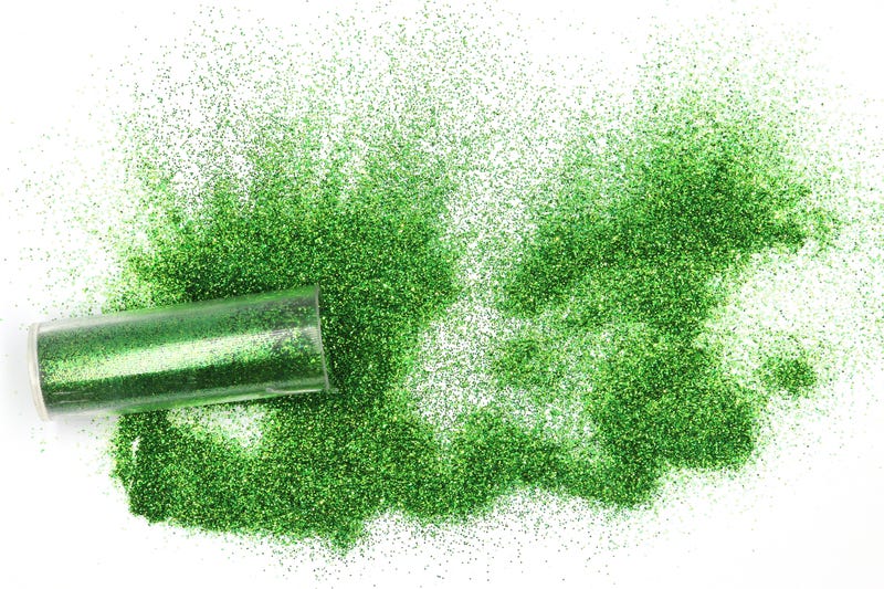 Jar with spilled green glitter Magical, celestial green glitter spilling out of a jar isolated on white background