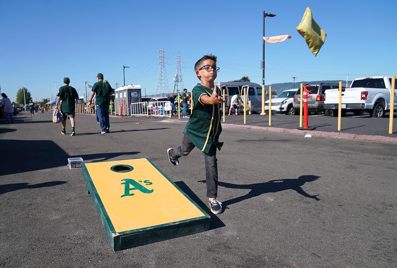 A young Oakland Athletics fan playing the game corn hole in the parking lot prior to the start of the American League WildCard Game against the Tampa Bay Rays at RingCentral Coliseum on October 2, 2019 in Oakland, California.
