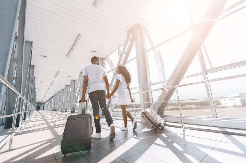 couple walking through the airport with luggage