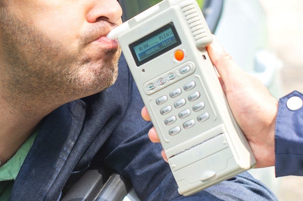 Man blowing into breathalyzer