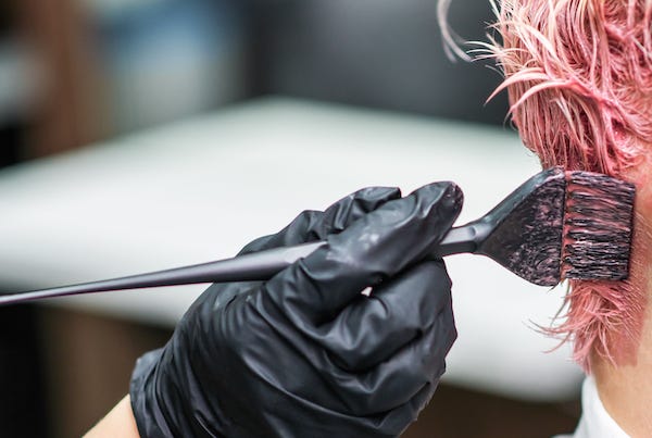Hairdresser dying hair pink
