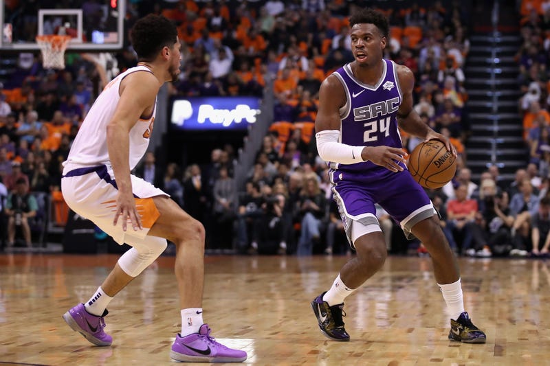 Devin Booker defends Buddy Hield on the perimeter.