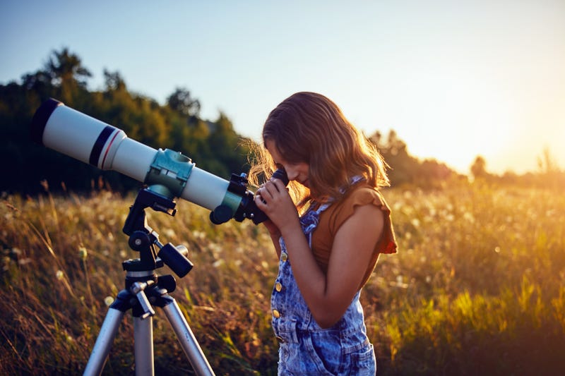 Little girl using telescope