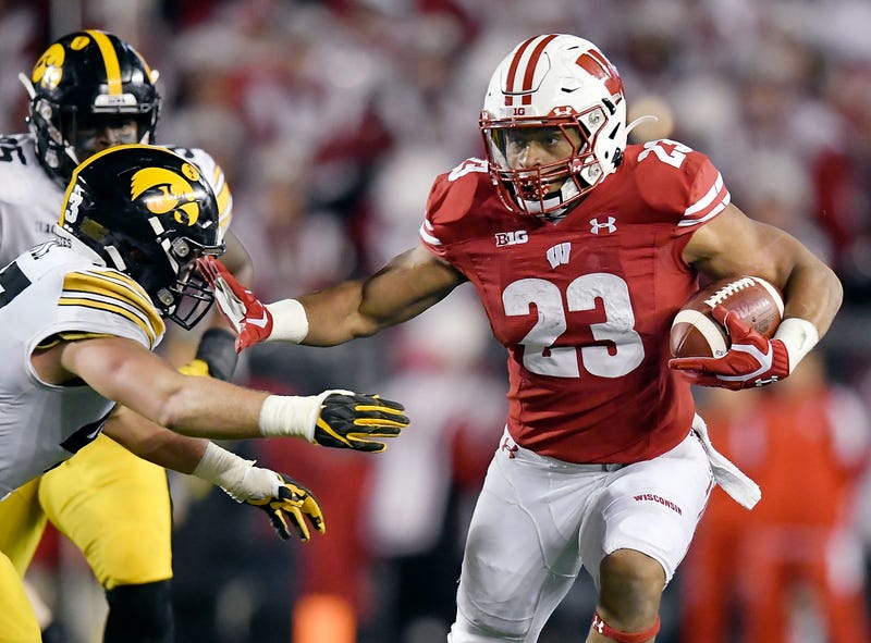 Wisconsin's Jonathan Taylor stiff-arms a defender