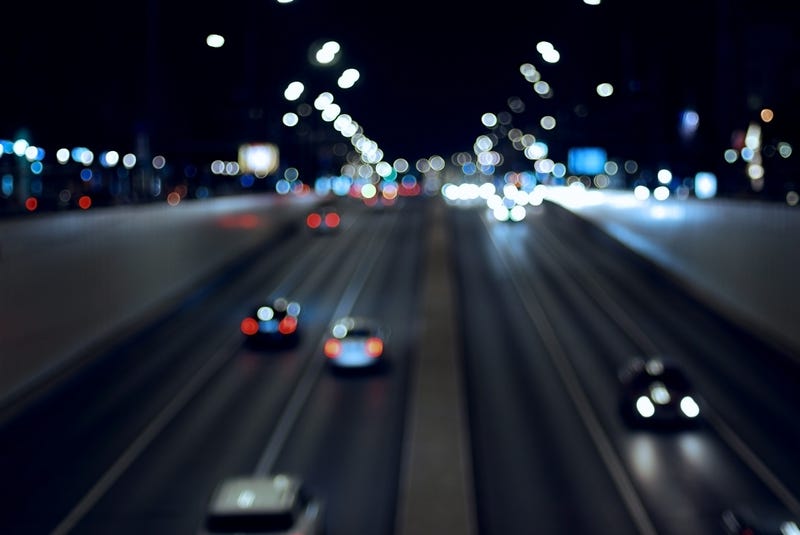 Blury night city traffic background, dark road and blurred cars in motion
