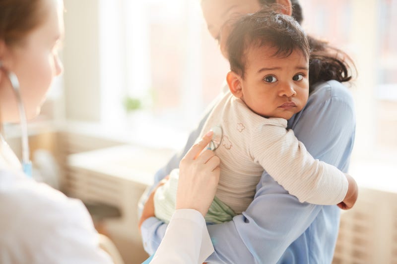 A baby being examined by a medical professional.