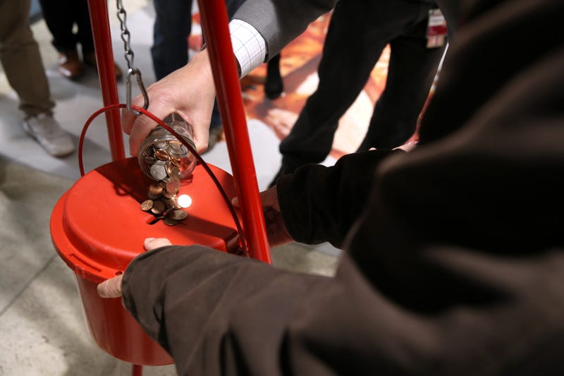 BART Board President Bevan Dufty pours change into a Salvation Army red kettle at the Powell Street Bay Area Rapid Transit (BART) station on December 03, 2019 in San Francisco, California.