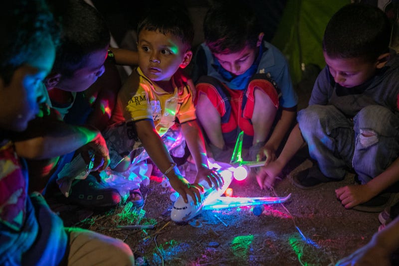 Honduran asylum seeker Michael, 2, secures his birthday present from fellow boys at an immigrant camp on December 08, 2019 in the border town of Matamoros, Mexico.