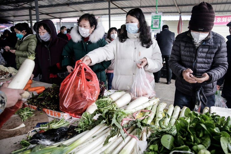 Residents wear masks to buy vegetables in the market on January 23, 2020 in Wuhan, Hubei, China. Flights, trains and public transport including buses, subway and ferry services have been temporarily closed and officials have asked residents told to stay in town in order to help stop the outbreak of a strain of coronavirus