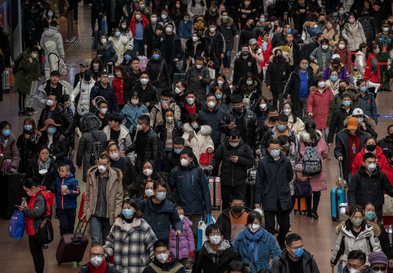 Chinese passengers, most wearing masks, arrive to board trains before the annual Spring Festival at a Beijing railway station on January 23, 2020 in Beijing, China. The number of cases of a deadly new coronavirus rose to over 500 in mainland China Wednesday as health officials locked down the city of Wuhan in an effort to contain the spread of the pneumonia-like disease.