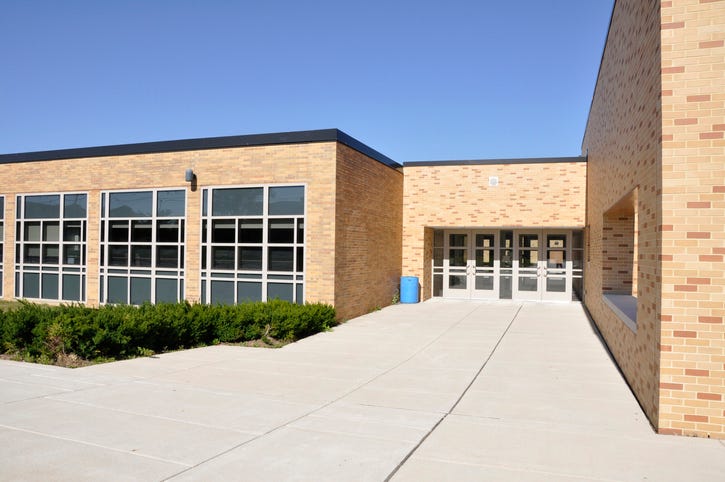 The main walkway leading up to a high school on a sunny day