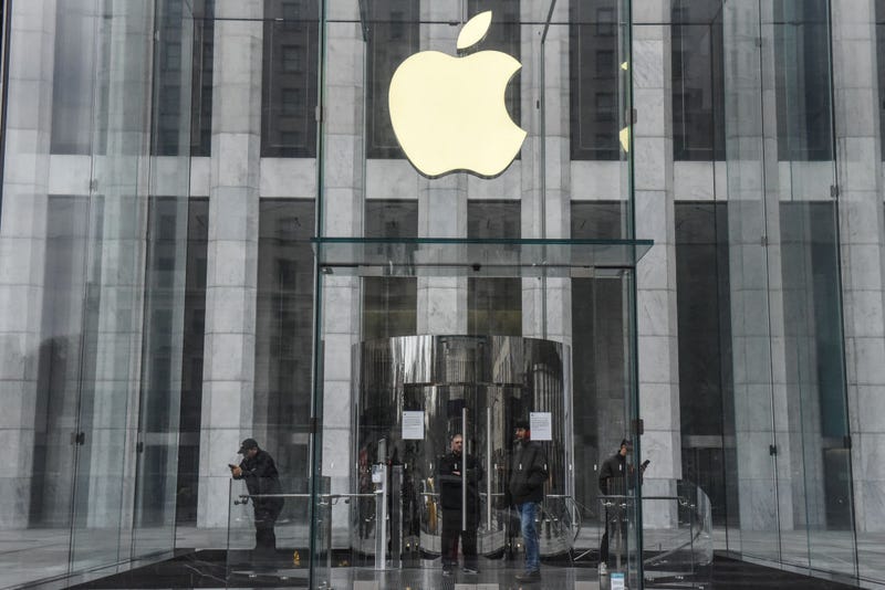 Employees at the flagship Apple store on Fifth Avenue stand at the entrance during the store's closure on March 15, 2020 in New York City.