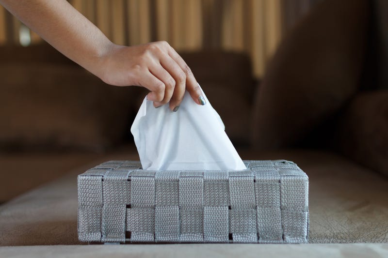 A woman's hand takes a tissue from a box