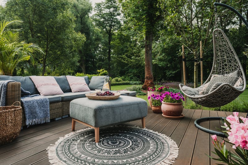Backyard scene with couch and hammock.