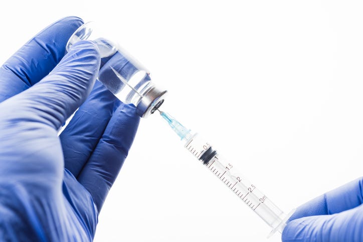 Doctor filling a syringe