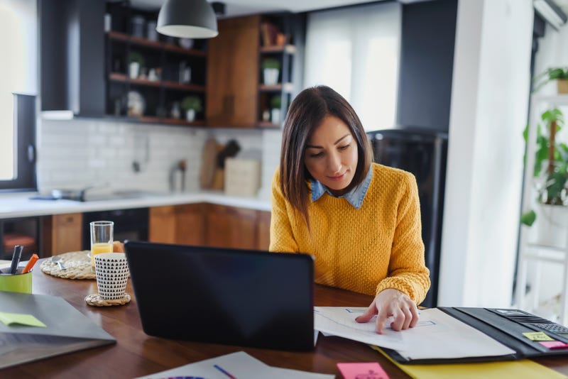 Young business entrepreneur woman working at home while having breakfast.