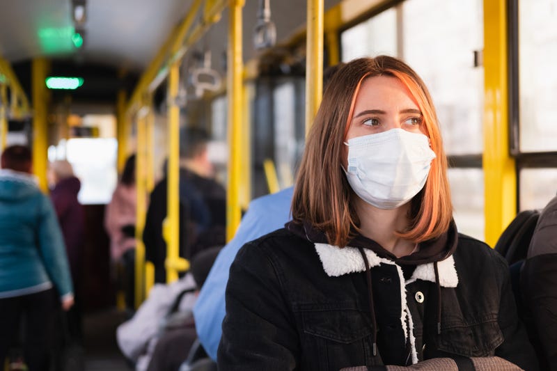 mujer en bus usando mascarilla