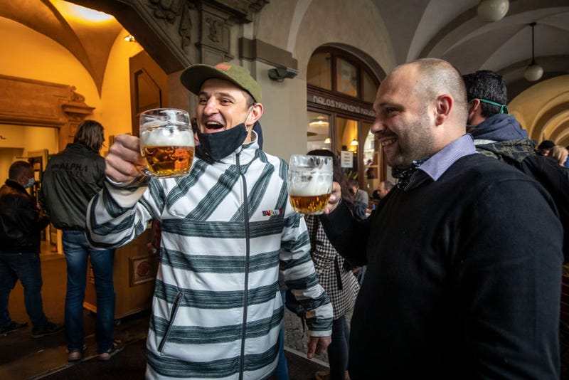 People drink beer at an outdoor seating section of a pub